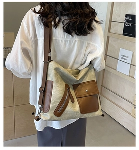Detail of vintage canvas tote with brown leather stitching and adjustable woven strap