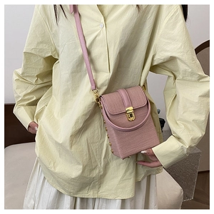 Detail of pink woven texture phone bag with gold twist lock and metal studs
