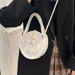 Mini round woven crossbody bag with colorful stitching and a gold tree charm