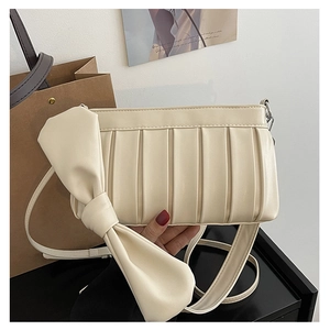 Dettaglio della borsa a tracolla plissettata color crema con fiocco decorativo grande