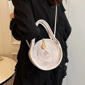 Mini round straw crossbody bag with colorful stitching and a decorative wood button