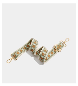 Detail of bohemian geometric embroidered wide shoulder strap with golden metal lobster clasps