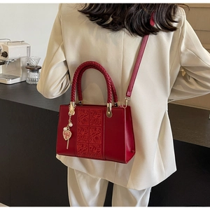 Detail of red wedding handbag with floral relief pattern and Chinese double joy pendant