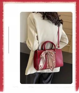 Detail of red wedding handbag with golden embroidery and elegant pink heart ribbon