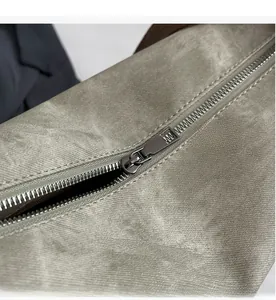 Close-up of smooth gunmetal zipper and durable gray canvas texture on the backpack