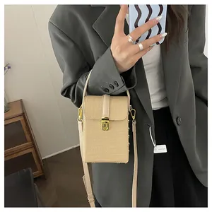 Detail of beige woven mini crossbody phone bag with gold metal buckle and leather strap