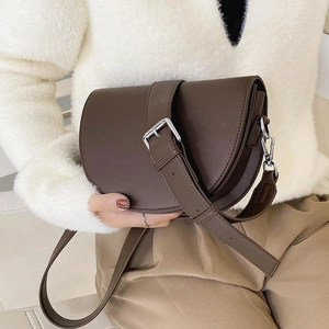 Deep brown matte leather saddle bag with wide adjustable strap and silver metal buckle