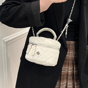 White quilted mini box bag with chain strap and camellia ornament shown on model