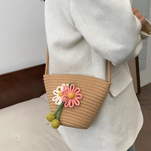 Handmade woven straw bucket bag with floral knit sunflowers and thin shoulder strap