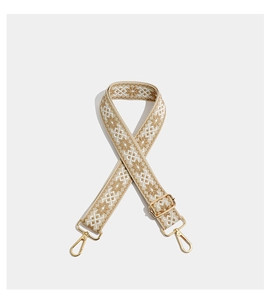 Macro shot of khaki bohemian embroidered bag strap with golden metal swivel hooks