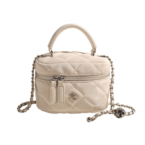 Elegant cream quilted bucket bag with gold flower clasp and chain strap in center view