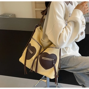 Detail of vintage canvas tote with heart-shaped leather pockets and long tassels