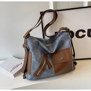 Close-up of grey-blue canvas tote with brown leather accents and multi-pocket detail