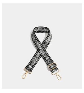 Detail of geometric embroidery on wide shoulder strap with golden metal lobster clasps