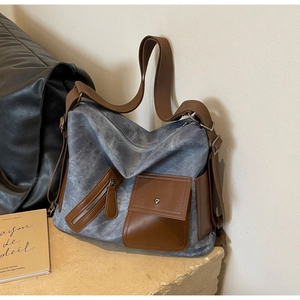Detail of vintage gray canvas tote bag with brown leather pockets and wide shoulder strap