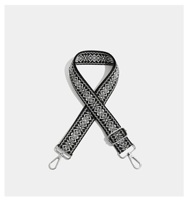 Detail view of monochrome geometric embroidered strap with adjustable silver metal hardware