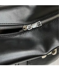 Detailansicht des silbernen Metallreißverschlusses und der Lederstruktur der schwarzen Tasche