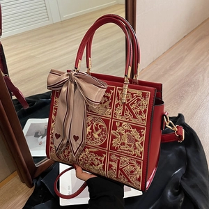 Elegant red wedding handbag with golden embroidery and decorative silk scarf
