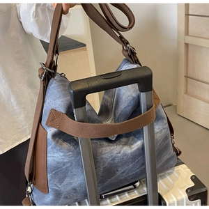 Detail of travel tote bag featuring a practical trolley sleeve for luggage handles