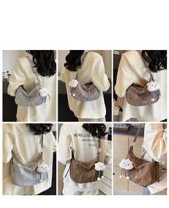 Detail view of crescent shoulder bag with metallic pleated texture and cloud charm