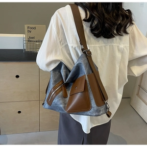 Detail of blue canvas and brown leather crossbody bag showing multiple utility pockets
