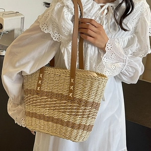 Striped woven straw tote bag with brown leather handles for summer beach vacation