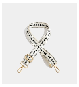 Detail of adjustable bohemian strap with black geometric embroidery and gold hardware