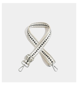 Detail of adjustable woven wide strap with black geometric pattern and silver metal hooks