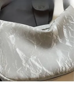 Detail of silver metallic tote bag featuring premium wrinkled texture and industrial fabric