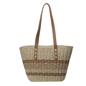 Large striped woven straw tote bag with brown leather handles for beach vacations