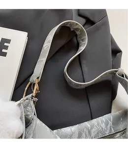Detailed macro view of the smooth grey marble textured shoulder strap and golden buckle