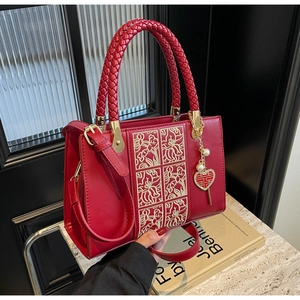 Detail of red bridal handbag with golden floral embroidery and pearl double happiness charm