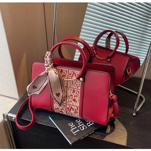 Detail of red bridal handbag with golden embroidery, silk scarf and detachable strap