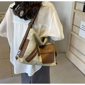 Detail of vintage canvas tote bag with brown leather trim and multiple storage pockets