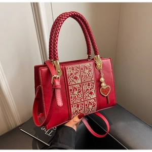 Detail of red wedding handbag with floral embroidery and heart-shaped Double Happiness charm