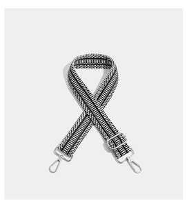Detail of black and white geometric woven strap with silver metal swivel hooks