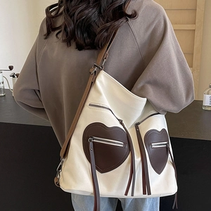 White canvas tote bag with brown heart pockets and long tassel zipper detail