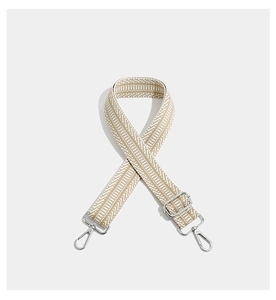 Detail of adjustable geometric embroidered bag strap with silver metal lobster clasps