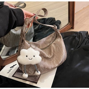 Detail of mocha pleated crossbody bag with metallic sheen and cute cloud charm