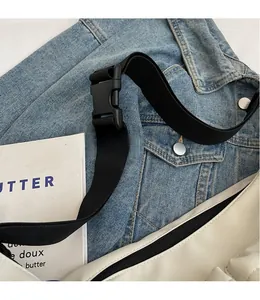 Detail of adjustable black nylon wide strap and buckle on white canvas tote bag