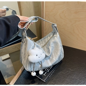 Close-up of silver-gray hobo bag with metallic pleated leather and cloud plush charm