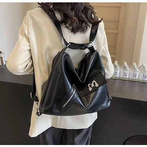 Detailansicht eines schwarzen Lederrucksacks mit silbernem M-Logo und Reißverschlussdetails