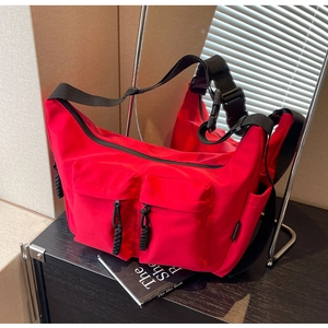 Detail view of bright red canvas tote with dual utility pockets and black woven pulls