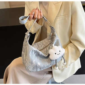 Detail of light gray pleated shoulder bag with a cute white cloud plush pendant accessory
