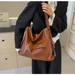 Detail einer braunen Leder-Tote-Bag mit M-förmiger Schnalle und Reißverschluss
