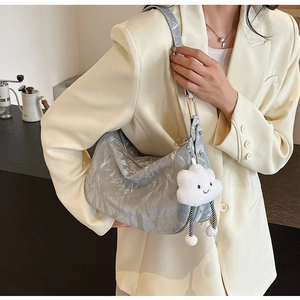 Detail view of silver pleated hobo bag with a cute white cloud plush pendant