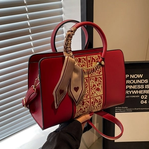 Elegant red wedding handbag with gold floral embroidery and decorative silk scarf