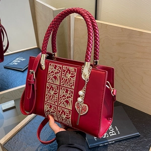 Elegant red wedding handbag with golden floral embroidery and pearl heart charm detail
