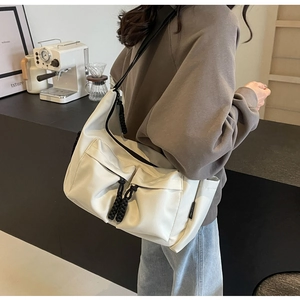 Detail of off-white canvas tote bag with black drawstring pockets in minimalist style