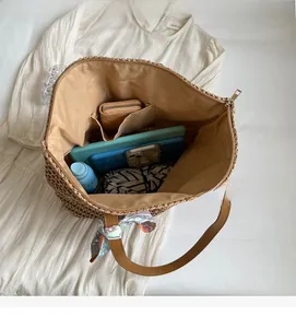 Top view of large woven straw tote bag showing spacious interior with scarf detail